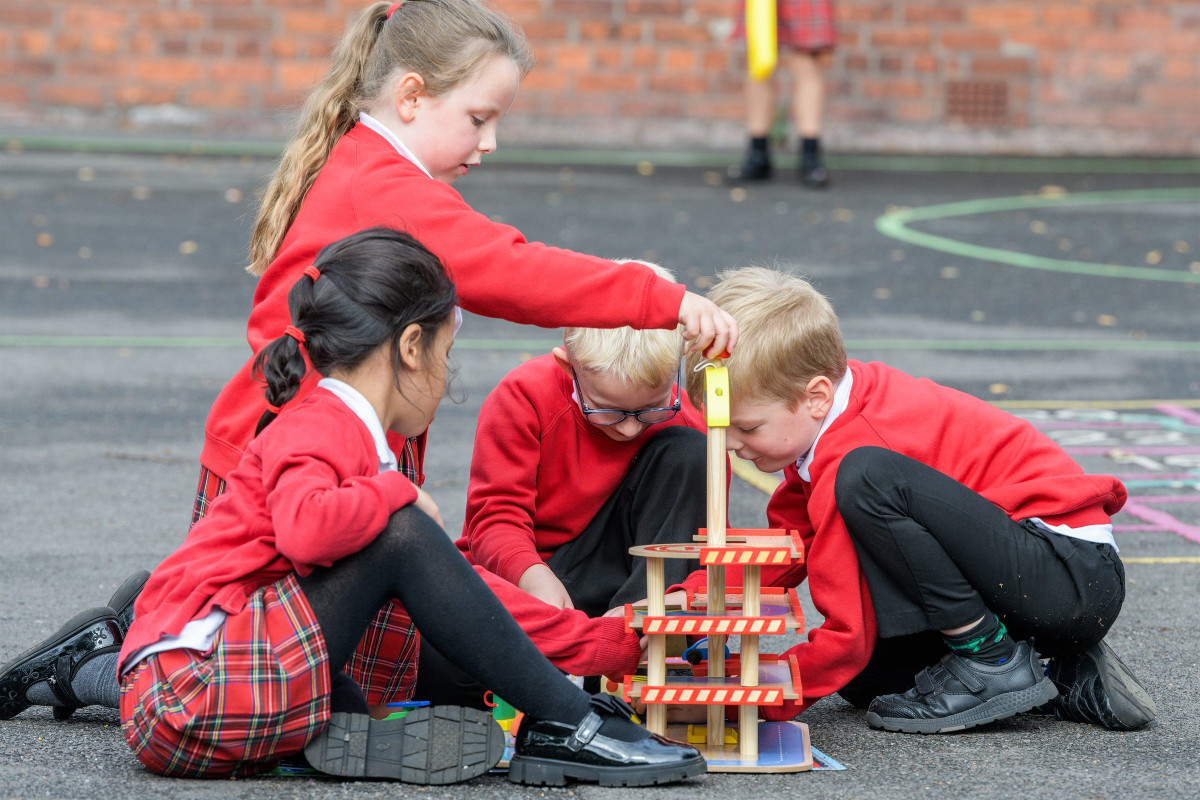 Children building a tower together on the playground