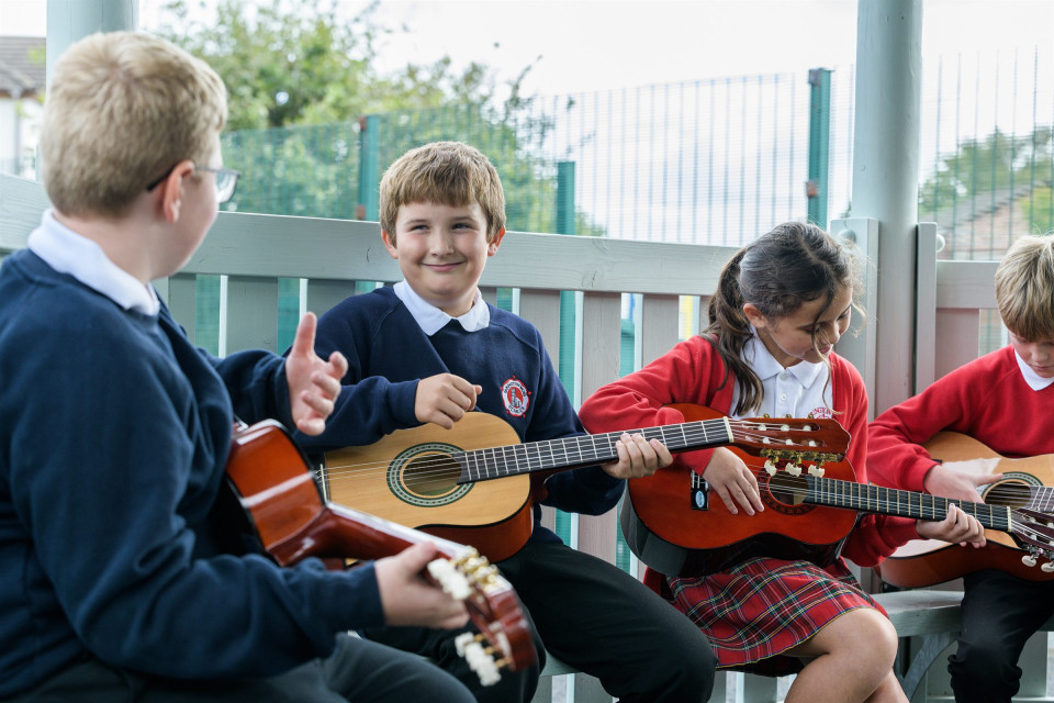 Children learning to play the guitar