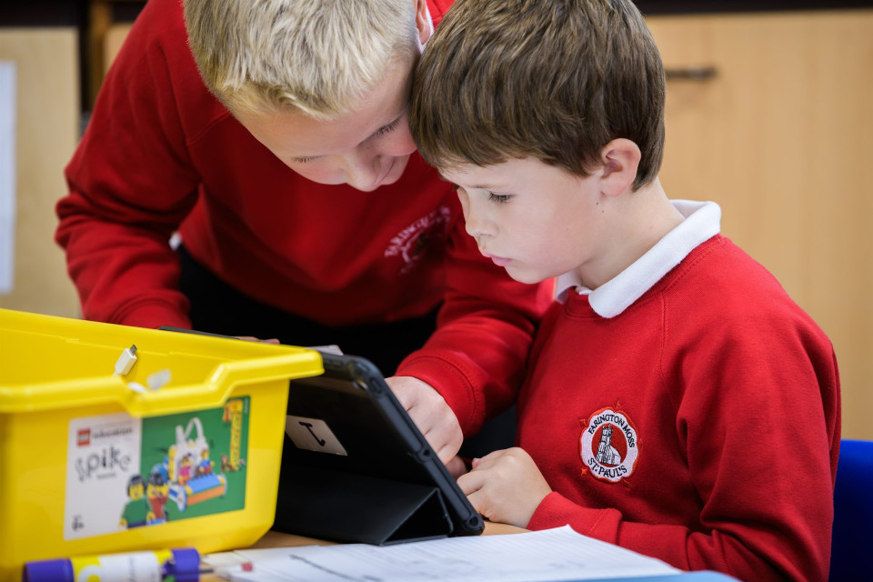 Two boys building with LEGO and a tablet